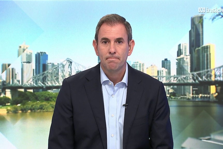 Jim Chalmers on the set of Insiders with an image of the Brisbane skyline behind him