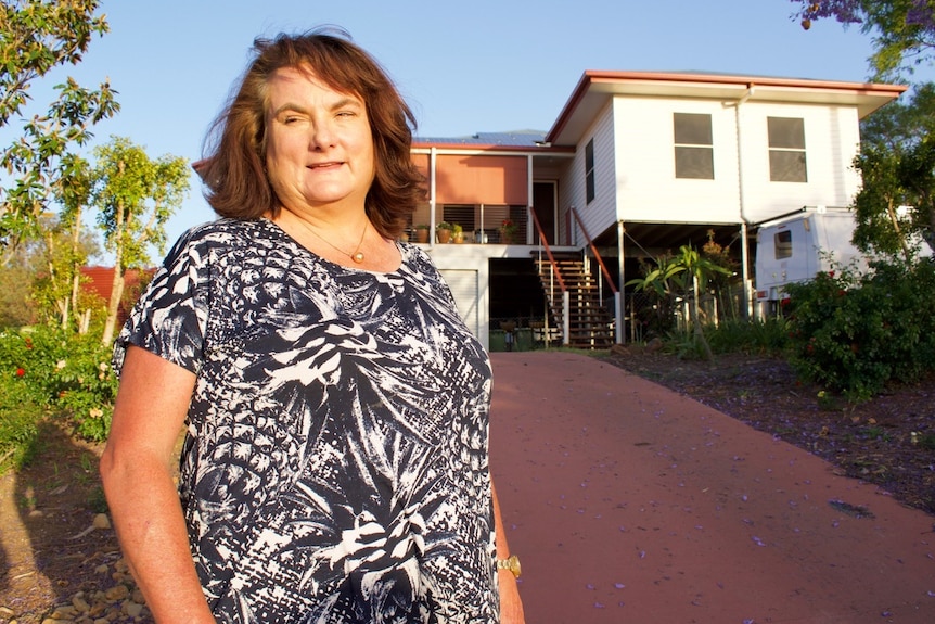 Therese Houghton stands outside her home.