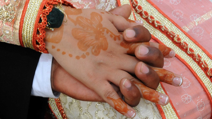 Bride and groom hold hands in traditional Moroccan-style wedding
