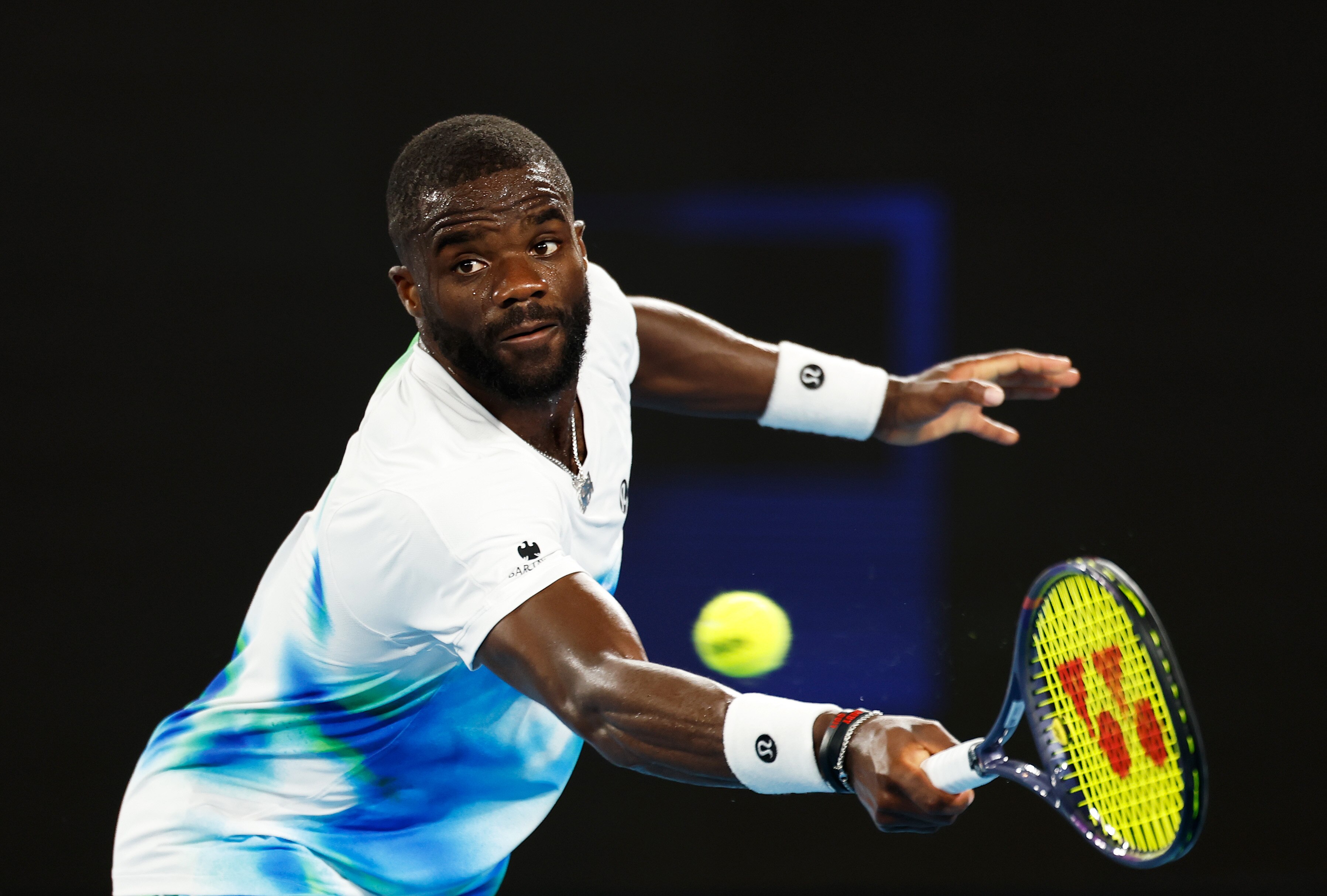 Frances Tiafoe se estende para um backhand no Aberto da Austrália.