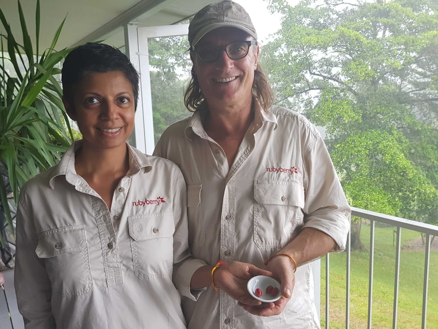 Karen Pereira and Chris Beckwith holding a small bowl of red berries