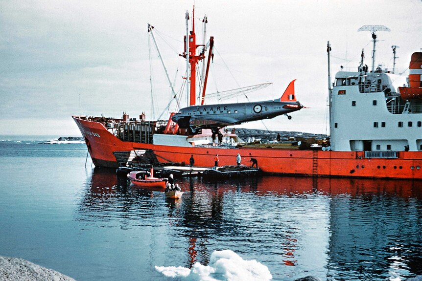 Picture of a plane being unloaded from an orange ship