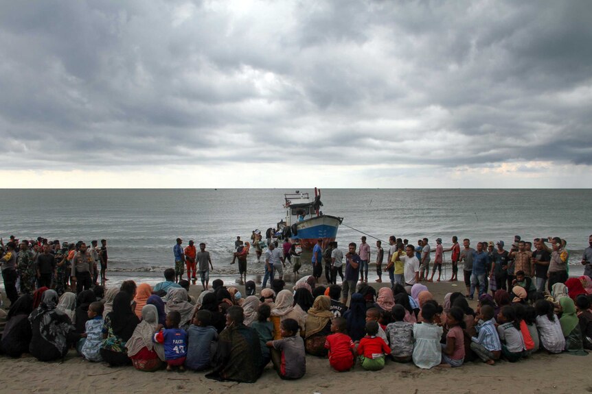 Rohingya refugees are evacuated by locals at a coast of North Aceh, Indonesia.