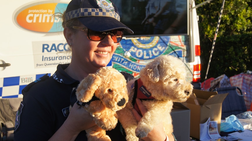 Police office holds dogs and a dog toy.