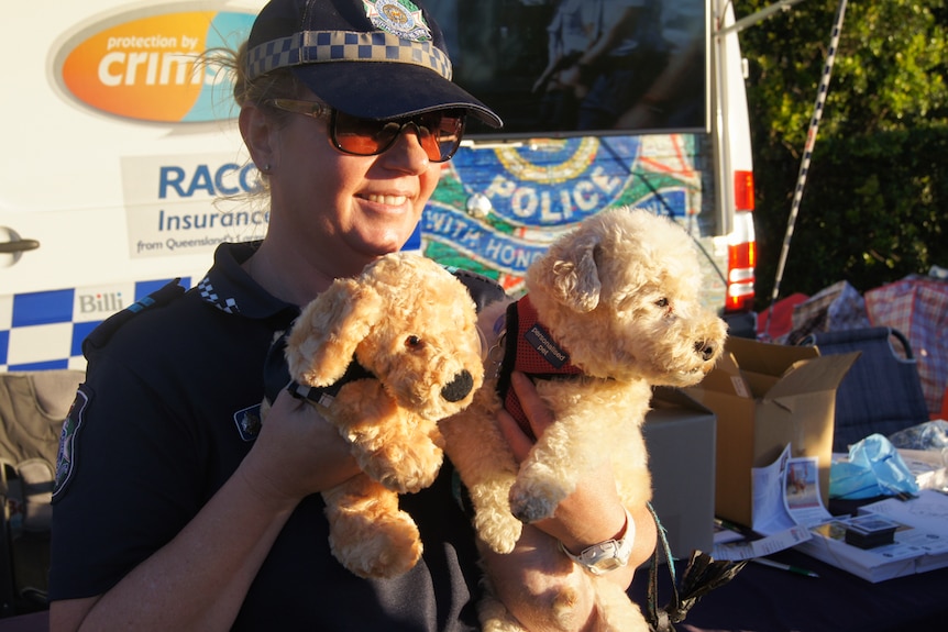 Police office holds dogs and a dog toy.