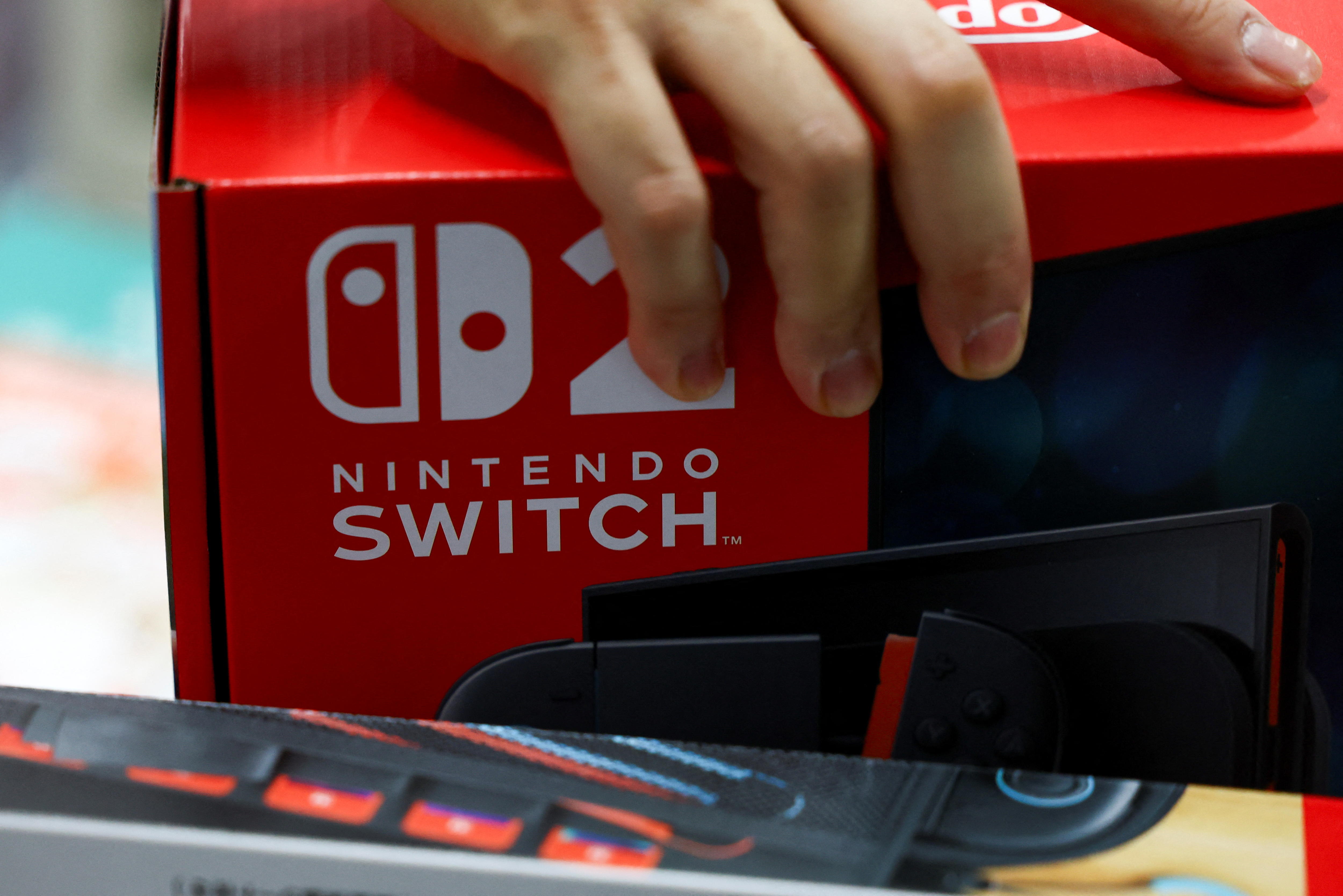 A person grabs a red box with the words 'Ninetendo Switch'. 