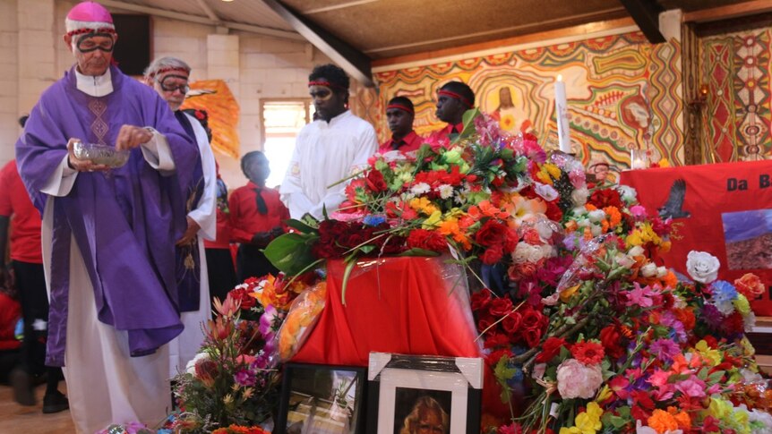 Priests sprinkle water on the coffin of Deacon Boniface Perdjert in Wadeye.
