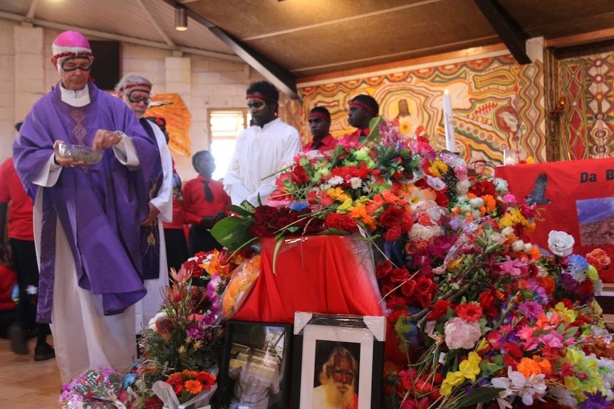 Priests sprinkle water on the coffin of Deacon Boniface Perdjert in Wadeye.