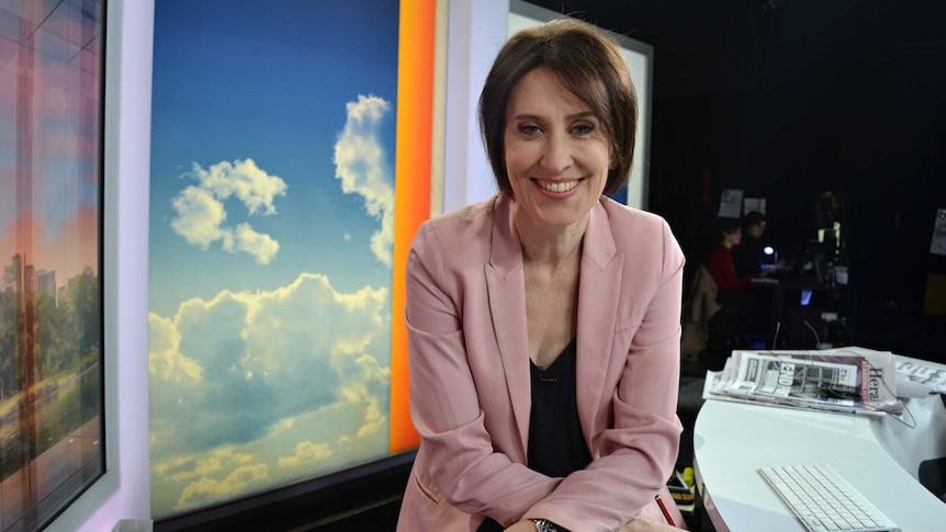 Virginia Trioli smiles as she sits at her presenter's chair on the News Breakfast set.