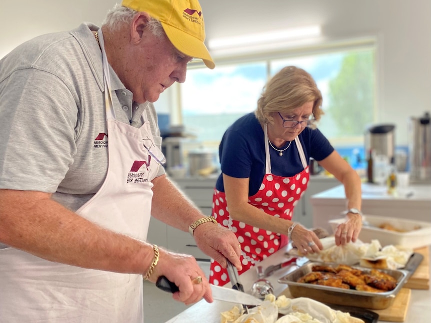 A man and a woman cooking in a commercial kitchen