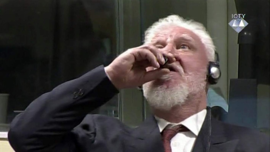 Slobodan Praljak tilts his head and brings a bottle to his lips