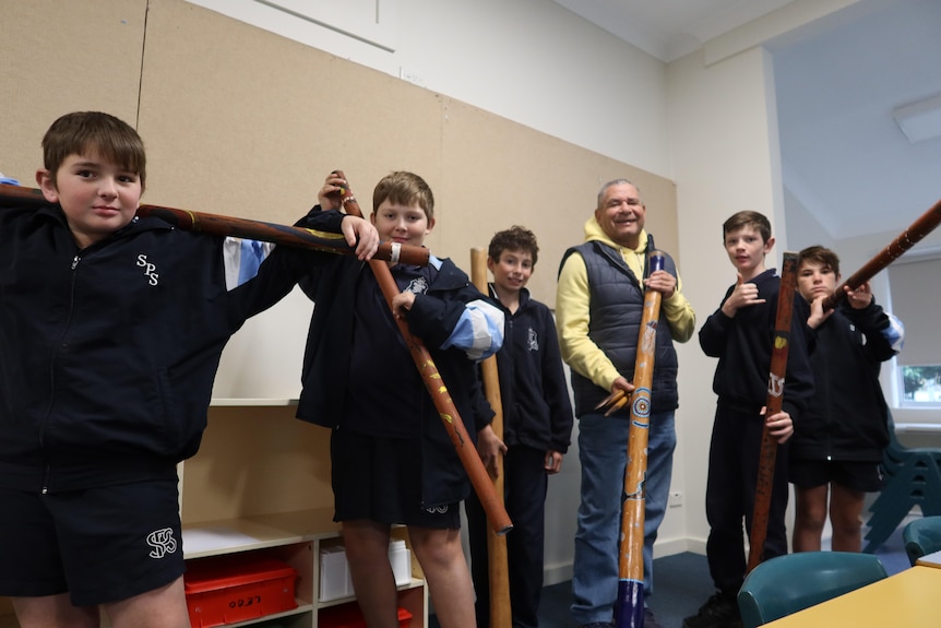 A group of kids with didgeridoos.