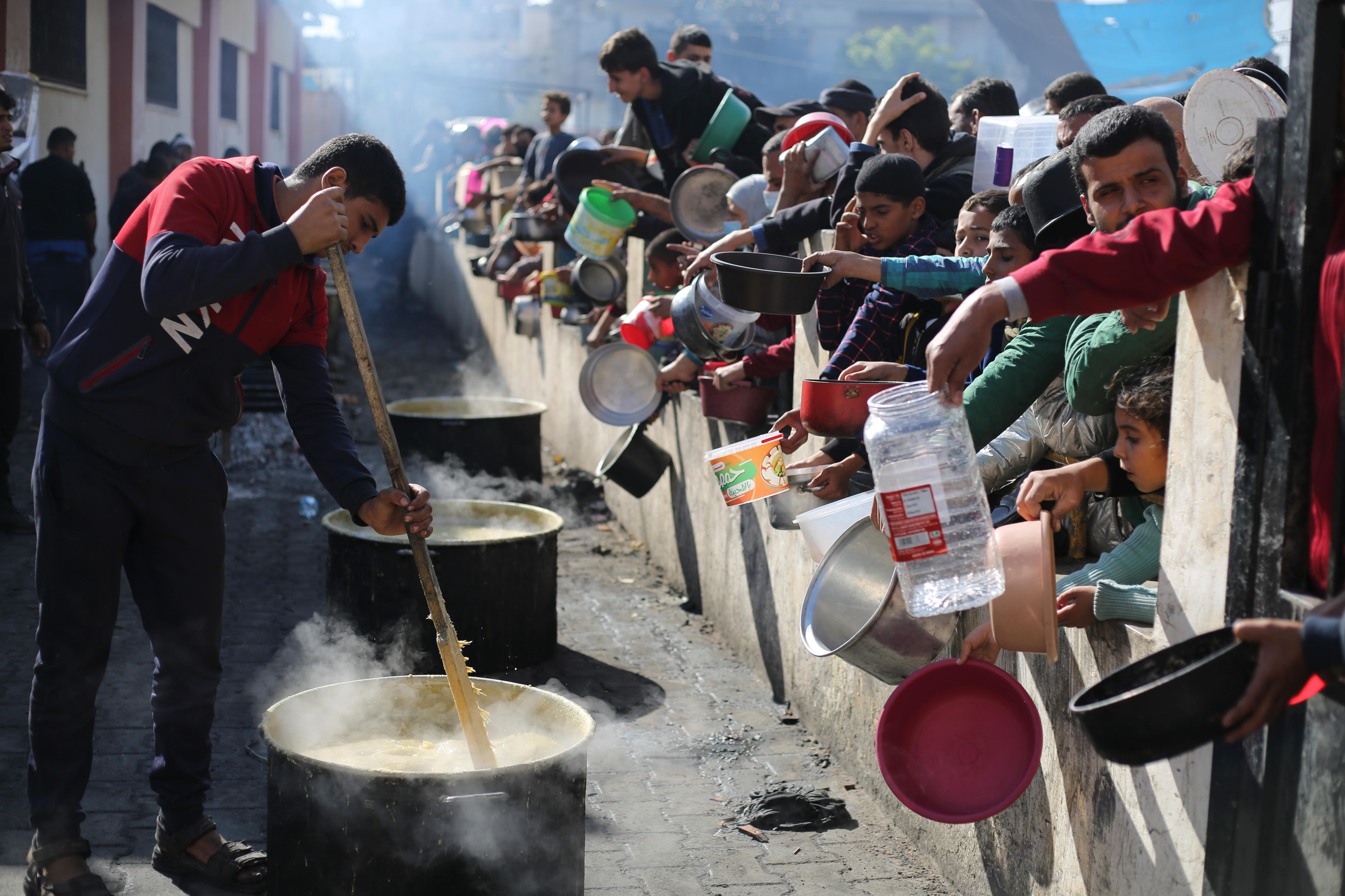 Palestinians line up for a free meal in Rafah, Gaza Strip