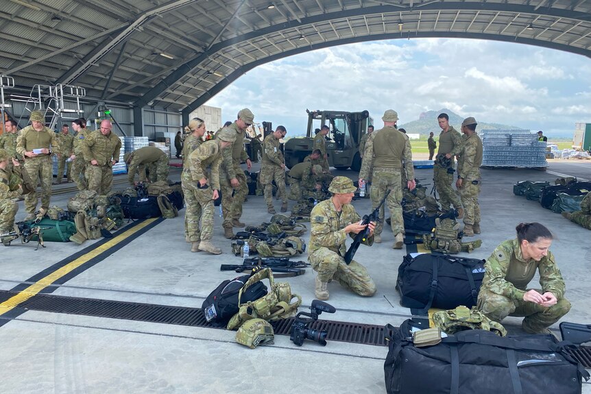 Australian Defence Force personnel checking weapons and equipment.
