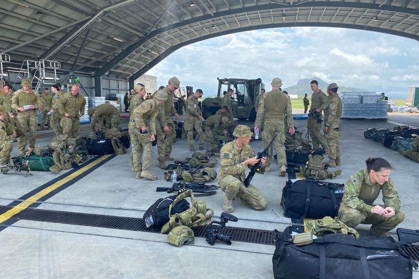 Australian Defence Force personnel checking weapons and equipment.