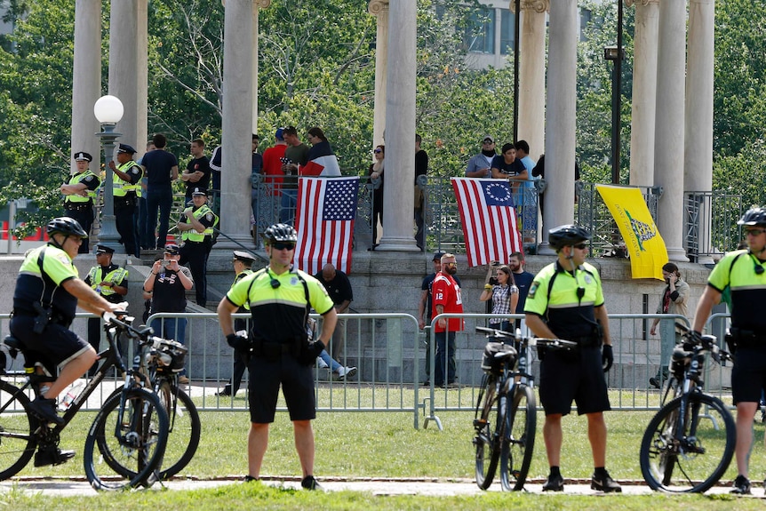 Police stand at a barricade around the bandstand before a planned "Free Speech" rally in Boston.