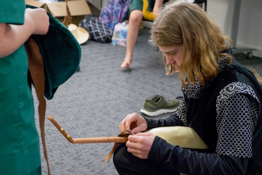 Dom Faggotter fixing the strap on a prop lute, Longreach, November 2022.