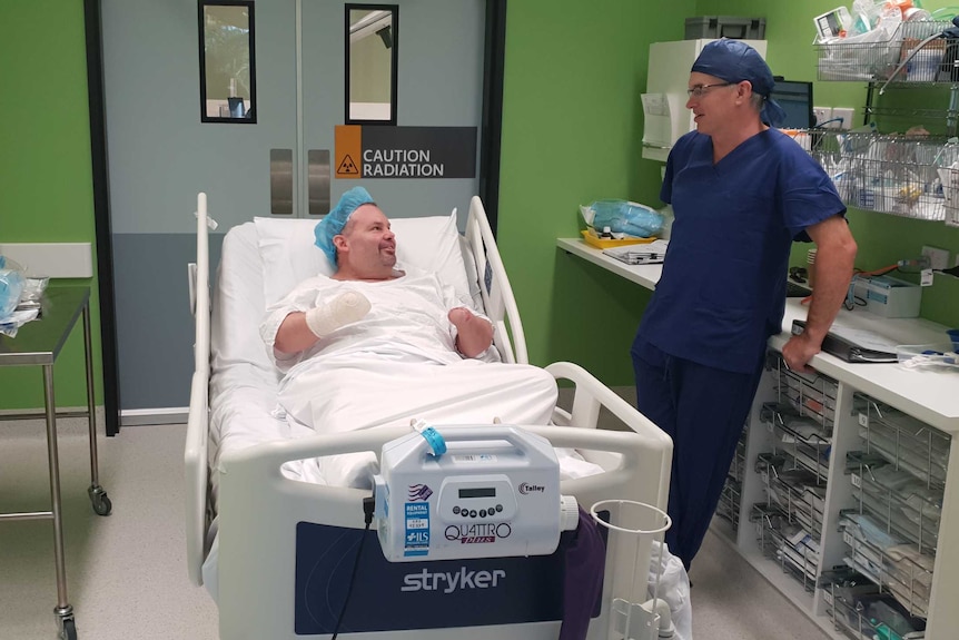 Buddy Miller in a hospital bed talking to a surgeon