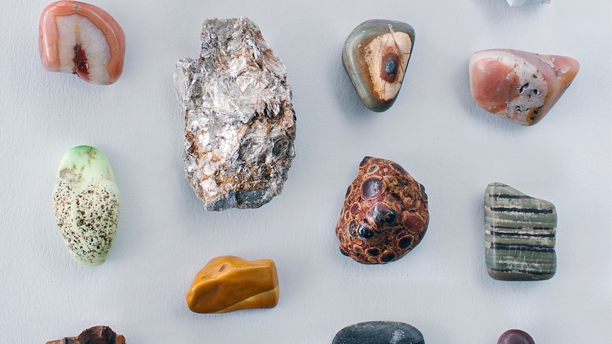 A collection of stones of different shapes and colours against a grey background
