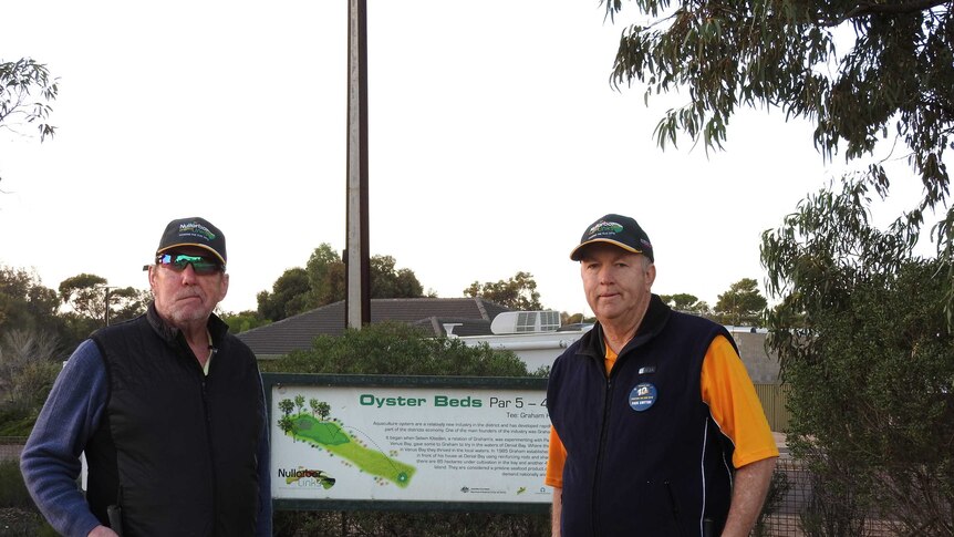 Two golfers standing in front of tees at Ceduna Golf Club.