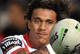 Tristan Sailor watches the ball as he sends out a pass for the Dragons during an NRL match