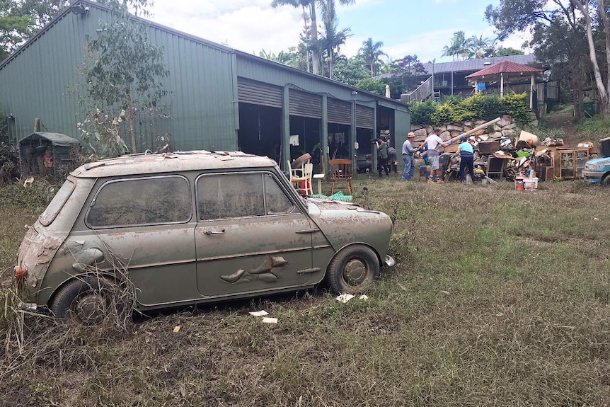 A car caked in mud from floodwaters.