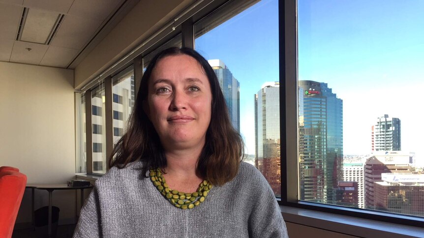 QNADA chief executive Rebecca Lang stands by her office window in Brisbane's CBD.