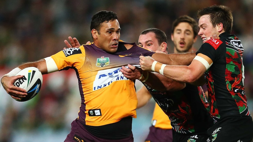 Justin Hodges fends off the defence
