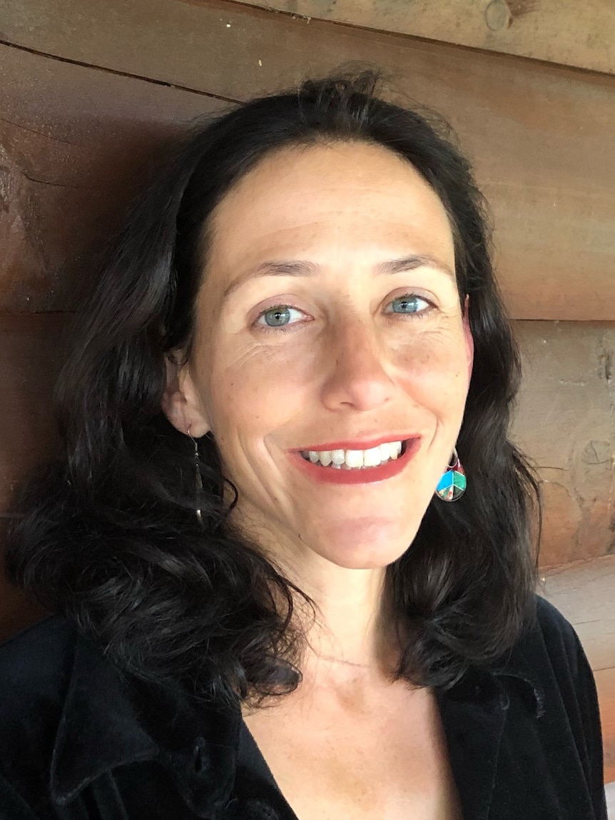 Eleanor Limprecht stands in front of a wood backdrop.