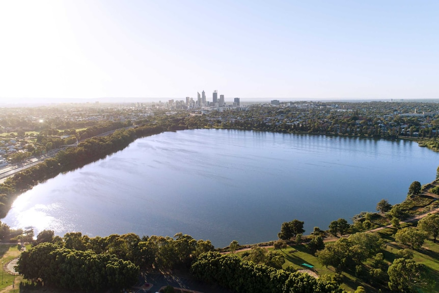An aerial shot of Perth's inner-city Lake Monger with the city's skyline in the background.