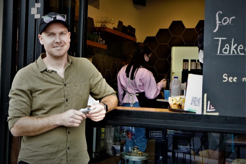 man standing at a coffee window 