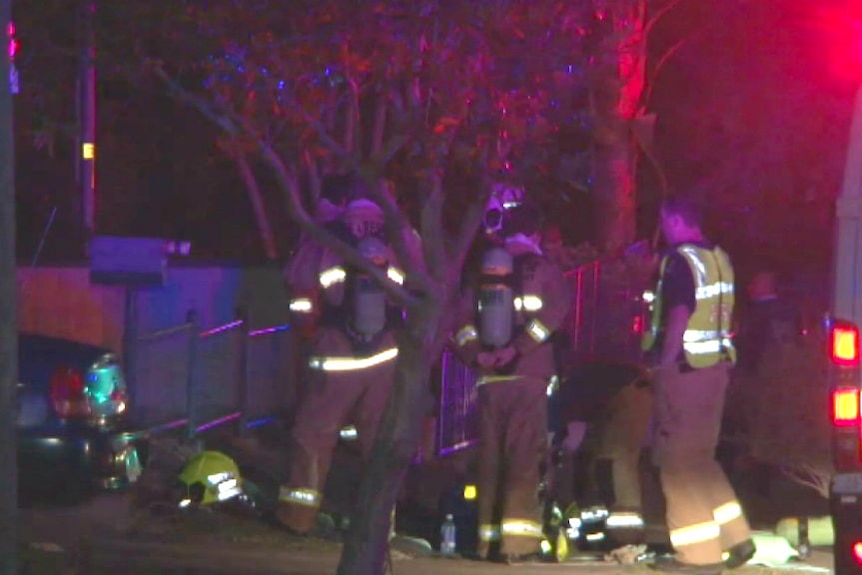 Fire crews outside a property where a woman died in a fire.