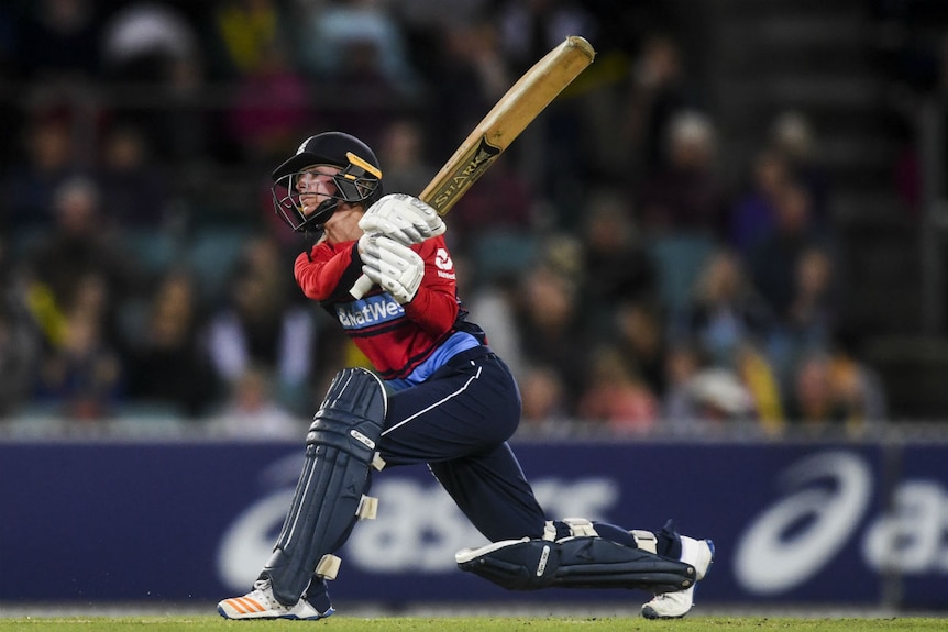 Danielle Wyatt swings a cricket bat.