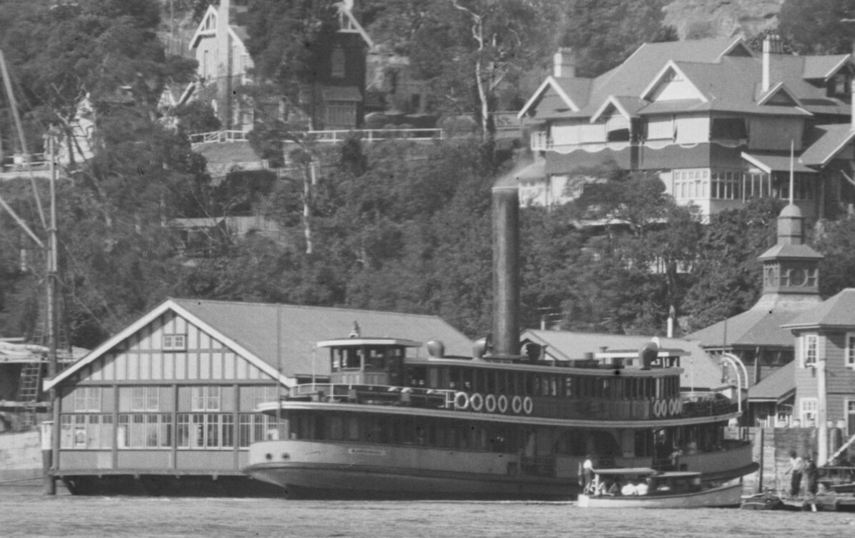 A black and white image of a large ship docked at a ferry terminal