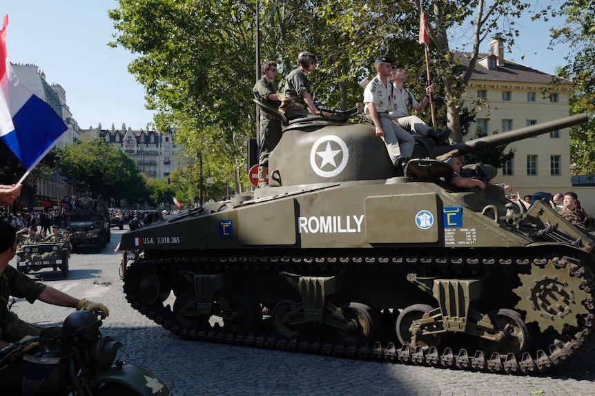 People dressed in World War II era clothes during celebrations of the liberation of Paris.