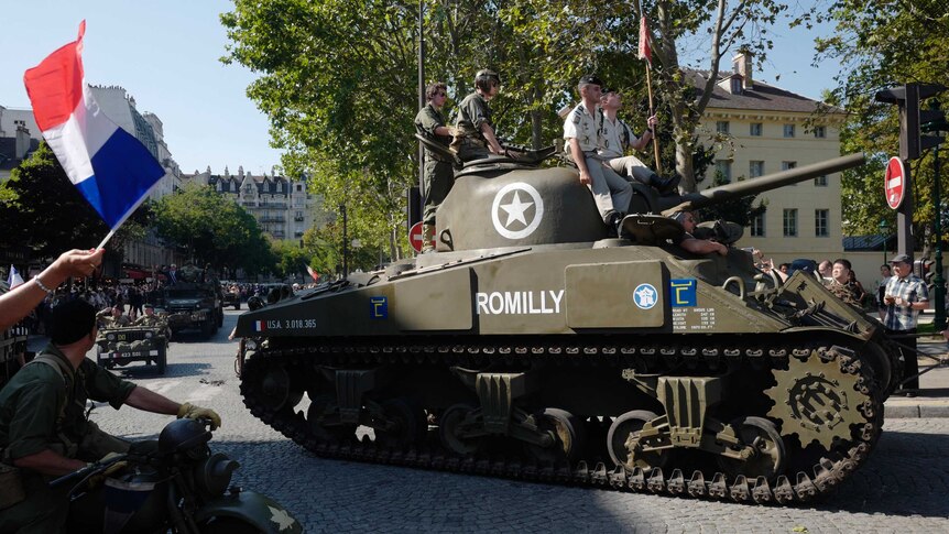 People dressed in World War II era clothes during celebrations of the liberation of Paris.