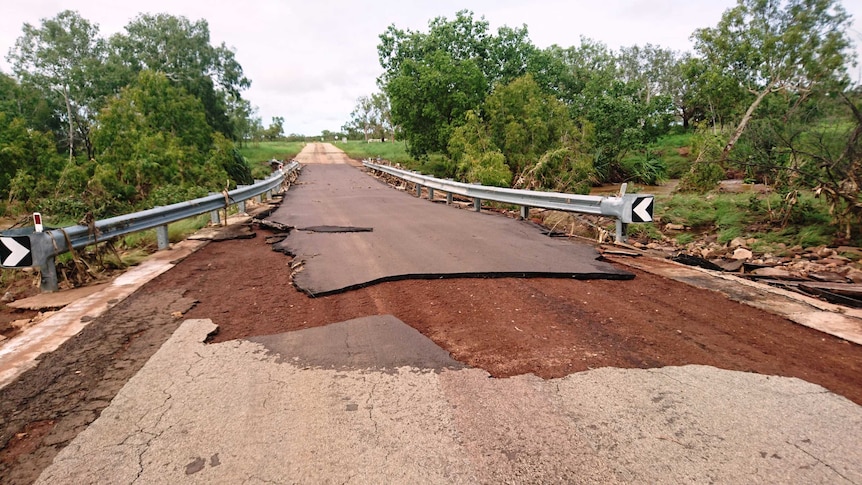 A close shot of a road that has had part of its bitumen ripped up and washed away.