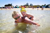 Mike Moran and his three-year-old son Hamish Wilson-Moran cool off at Brighton Beach