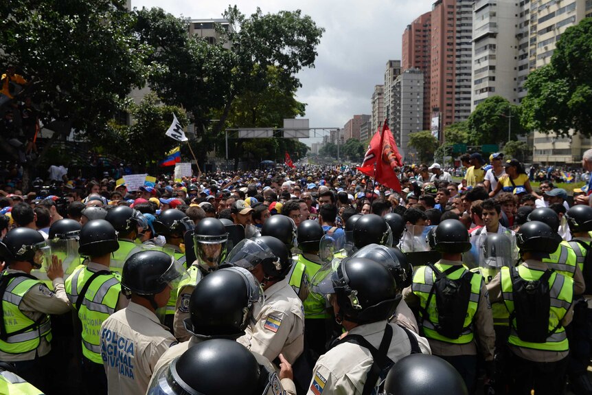 Crowds face police line in Caracas