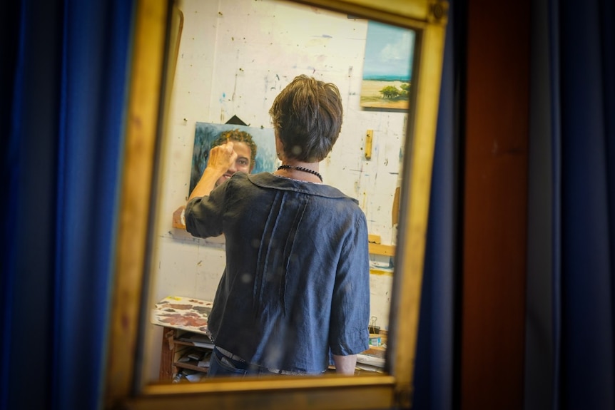 A woman works on a painting