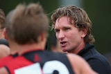 Essendon coach James Hird talks to players during the preseason game against St Kilda in Morwell.