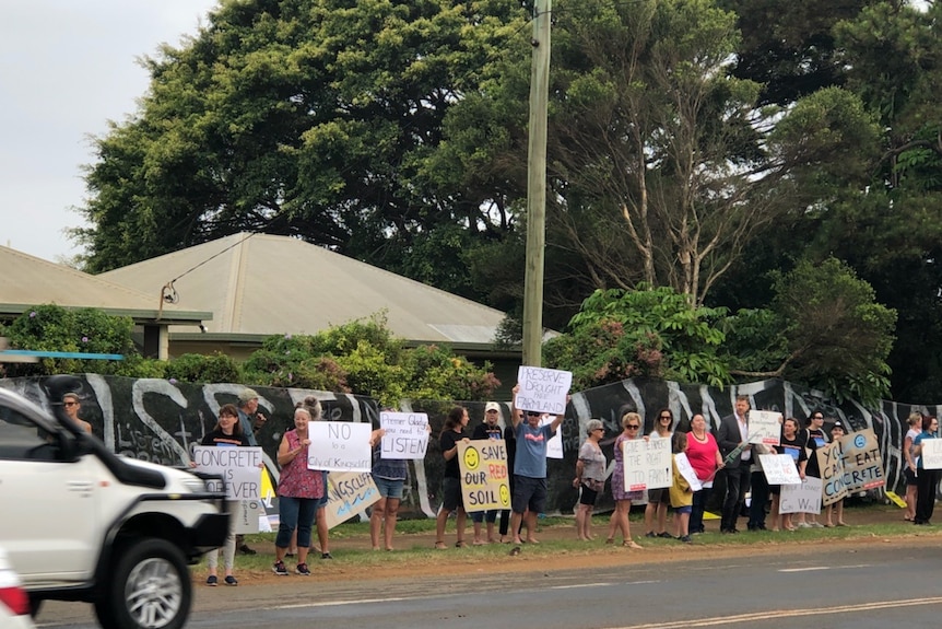 Protesters hold up signs at a new hospital site near Kingscliff.