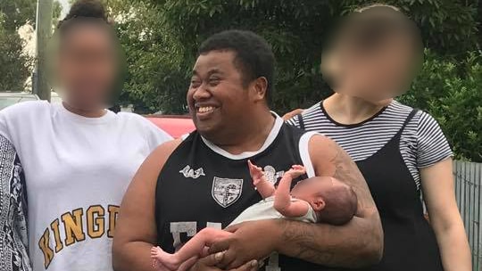 Max Lasea Tavai holds a baby in a family photo.