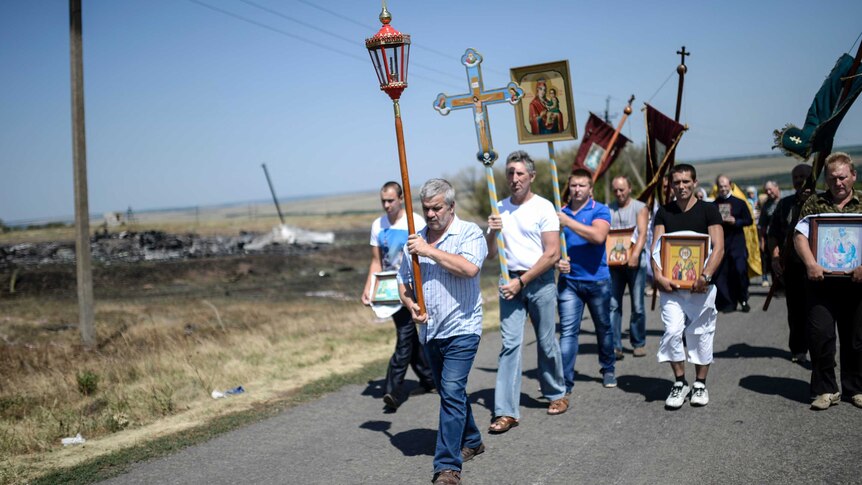 People attend a religious ceremony near the crash site of the Malaysia Airlines Flight MH17 near the village of Hrabove (Grabovo), some 80km east of Donetsk, on August 2, 2014.