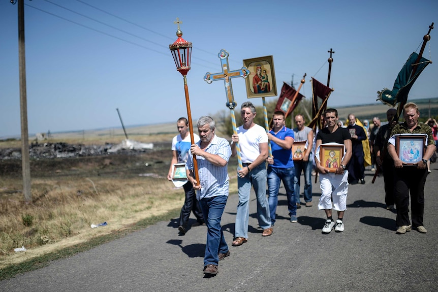 People attend a religious ceremony near the crash site of the Malaysia Airlines Flight MH17 near the village of Hrabove (Grabovo), some 80km east of Donetsk, on August 2, 2014.