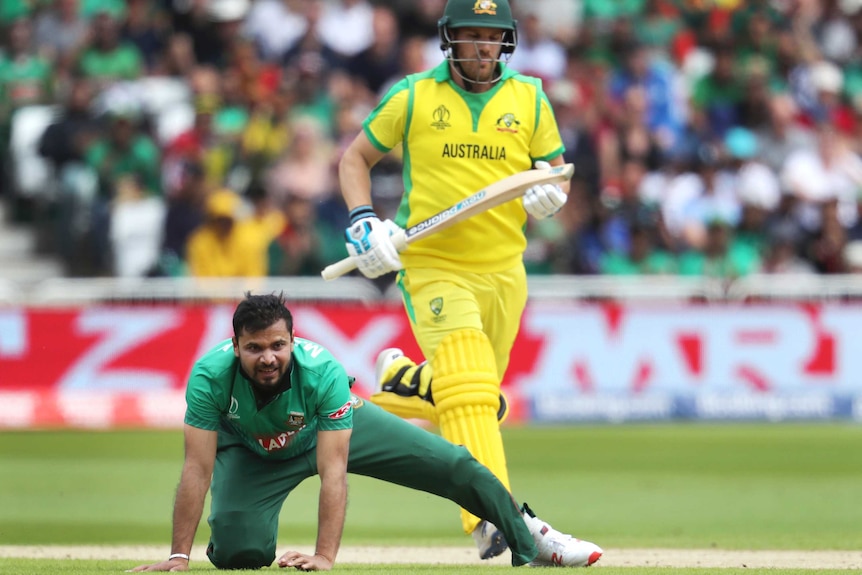 Mashrafe Mortaza is down on his hands and knees as Aaron Finch runs behind him