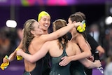 Female swimmers hug after a race
