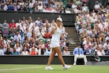 Female tennis players throwing her fist in the air in celebration after winning a match