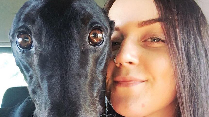 A woman hugs a dog