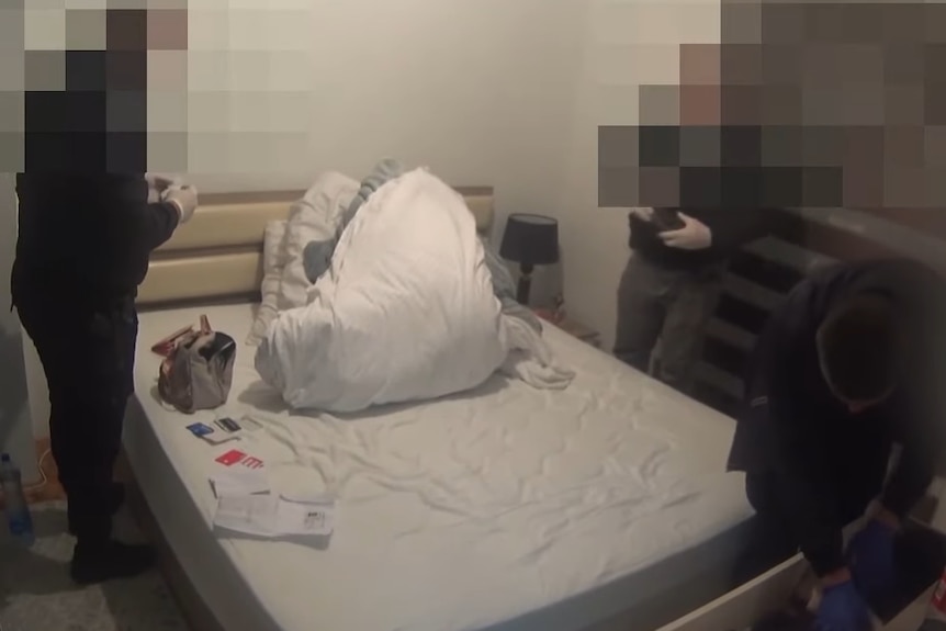 Pixilated police officers searching a bedroom 